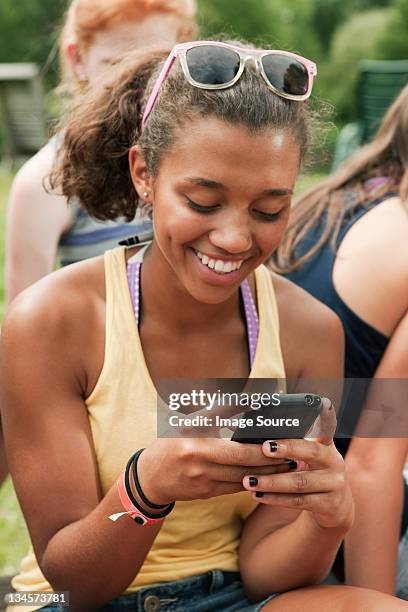 teenager-mädchen, die auf einem handy in der landschaft - 3 teenagers mobile outdoors stock-fotos und bilder