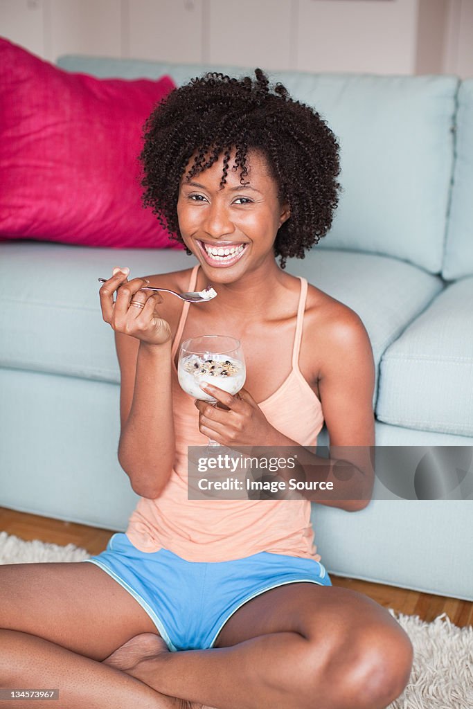 Young woman eating desert while relaxing at home