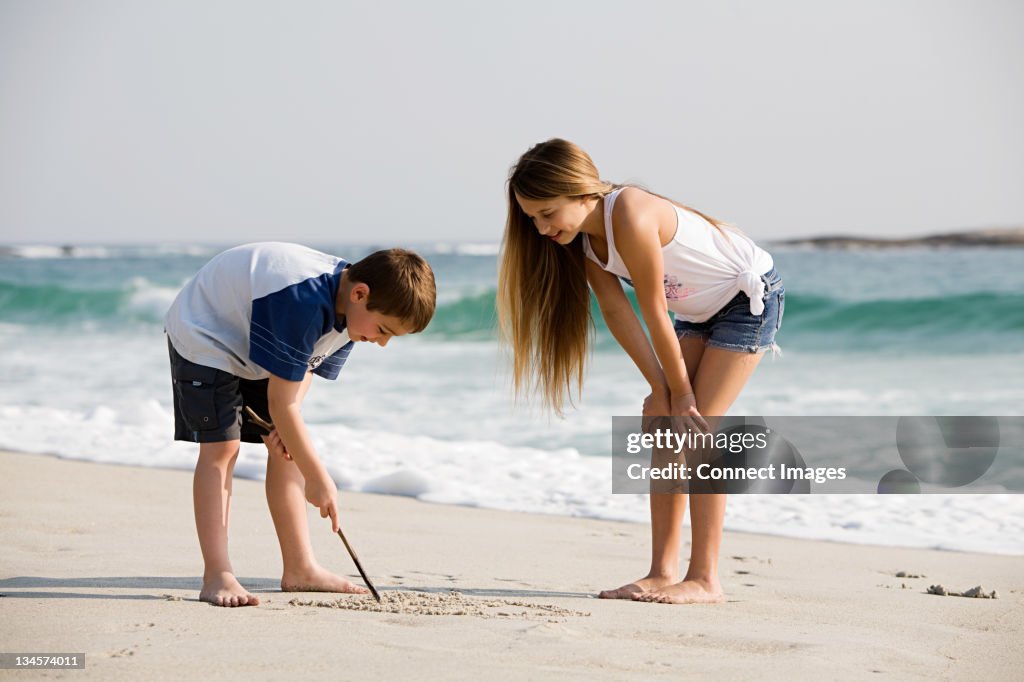 Menina e Menino desenho na areia imagens