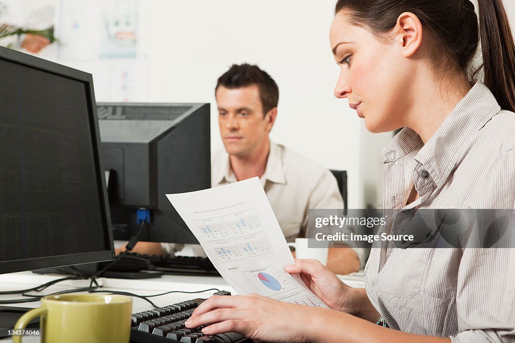 Office worker looking at graphs on a piece of paper
