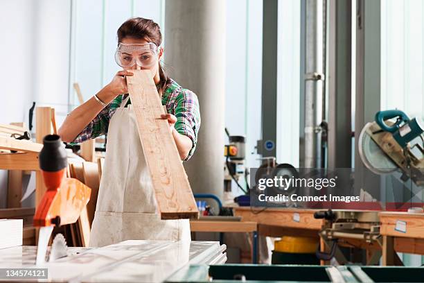 carpenter checking angle of wood in workshop - timmerman stockfoto's en -beelden