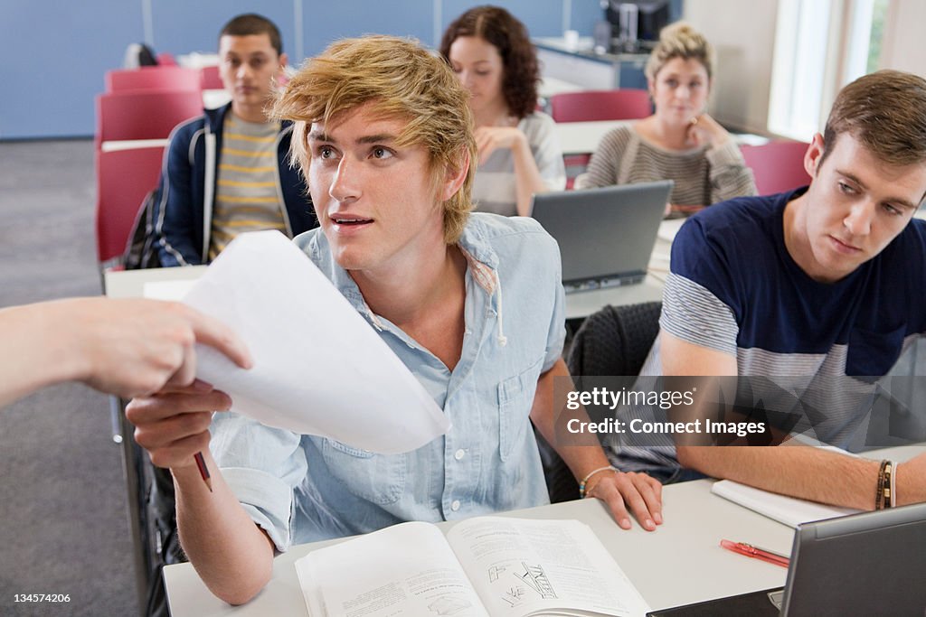 University student receiving exam paper