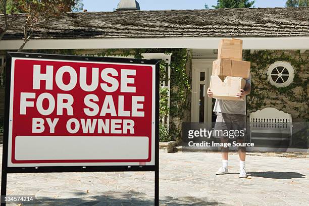mature man carrying boxes to move into newly bought property - exit sign ストックフォトと画像