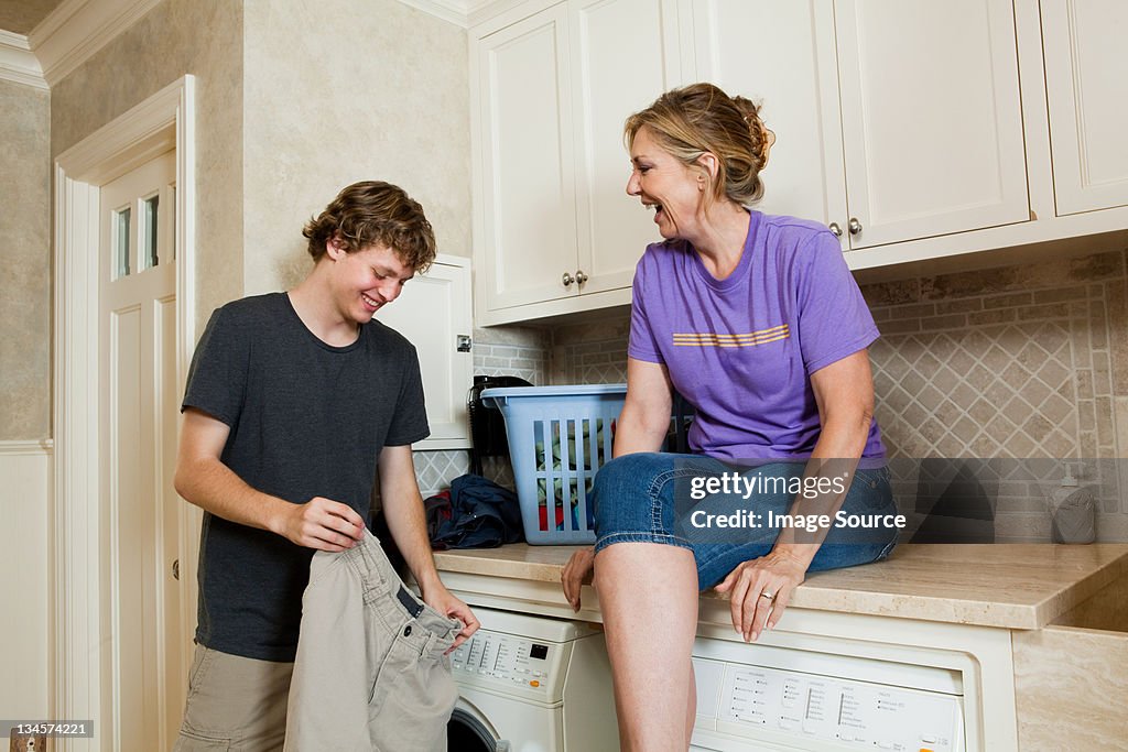 Mature woman and son in laundry room