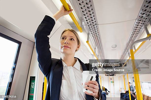 businesswoman travelling on london overground train - businesswoman in suit jackets stock-fotos und bilder