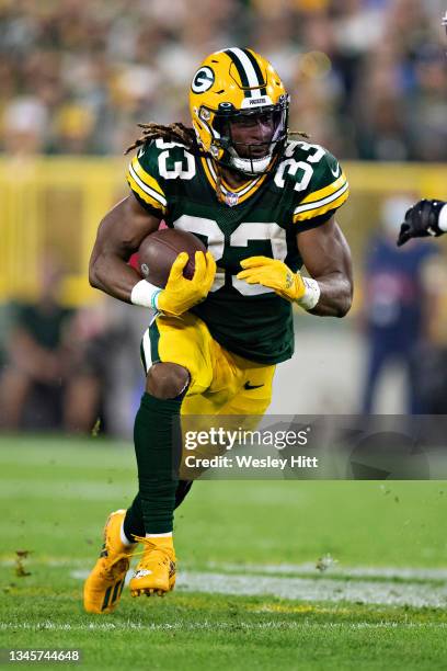 Aaron Jones of the Green Bay Packers runs the ball during a game against the Detroit Lions at Lambeau Field on September 20, 2021 in Green Bay,...