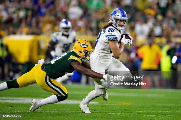 Hockenson of the Detroit Lions runs the ball after catching a pass and is tackled from behind by Adrian Amos of the Green Bay Packers at Lambeau...