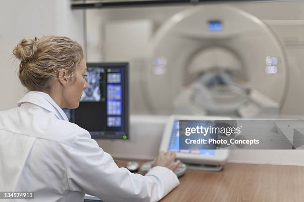 doctor operating ct scanner in hospital - medische apparatuur stockfoto's en -beelden