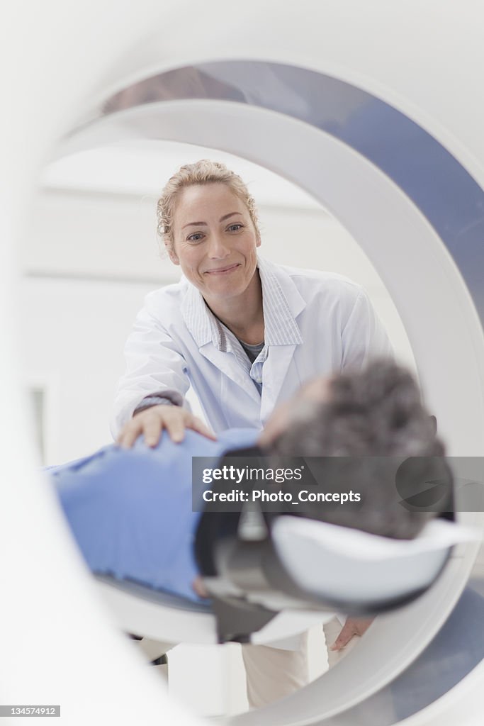 Doctor preparing patient for CT scanner