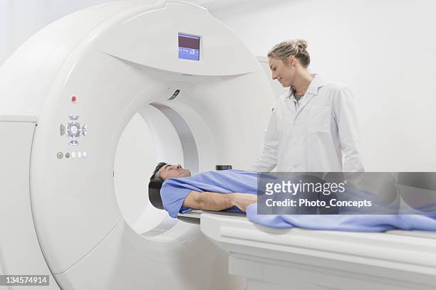doctor preparing patient for ct scanner - mri scanner stock pictures, royalty-free photos & images
