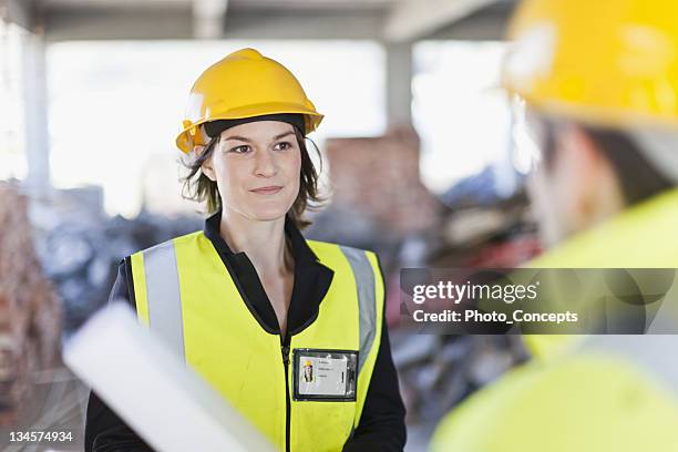 construction worker smiling on site - protective workwear for manual worker stockfoto's en -beelden