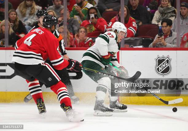 Kirill Kaprizov of the Minnesota Wild is pressured while trying to shoot by Seth Jones of the Chicago Blackhawks during a preseason game at the...