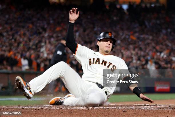 Wilmer Flores of the San Francisco Giants slides into home plate to score a run in the second inning against the Los Angeles Dodgers during Game 2 of...