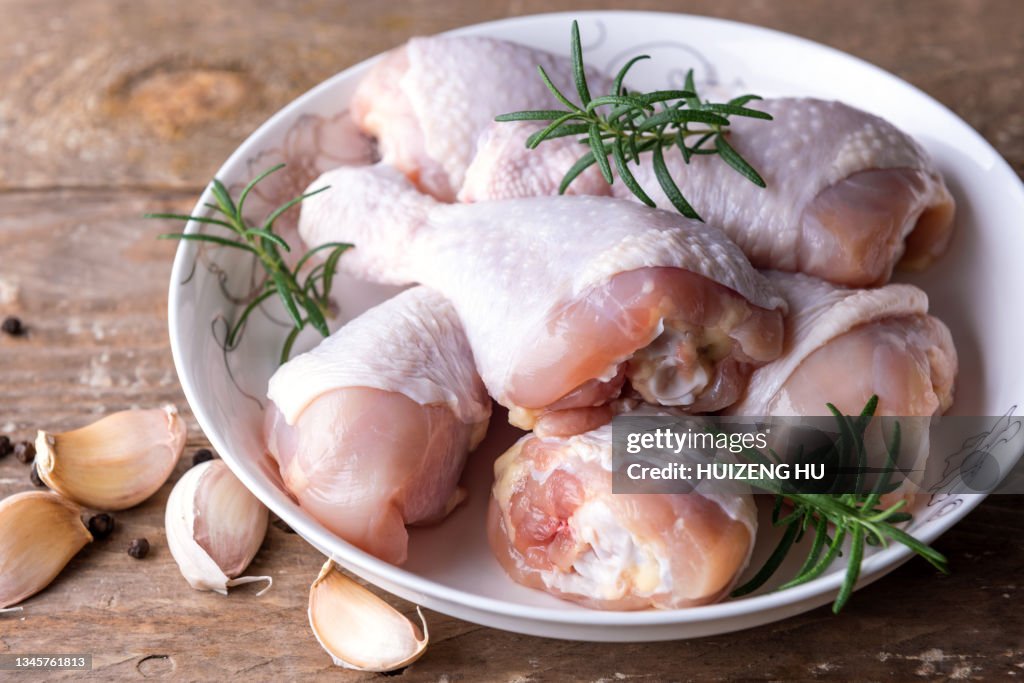 Raw uncooked chicken legs with spices drumsticks, meat with ingredients for cooking