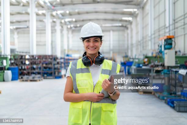 portrait of female engineer at factory - factory engineer woman stockfoto's en -beelden