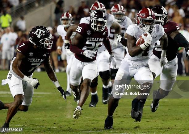 Brian Robinson Jr. #4 of the Alabama Crimson Tide runs past Demani Richardson of the Texas A&M Aggies and Tyreek Chappell at Kyle Field on October...