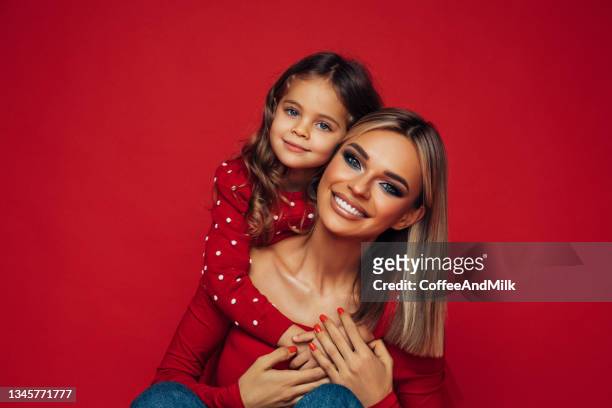 mère heureuse avec bébé enfant - portrait fond rouge photos et images de collection