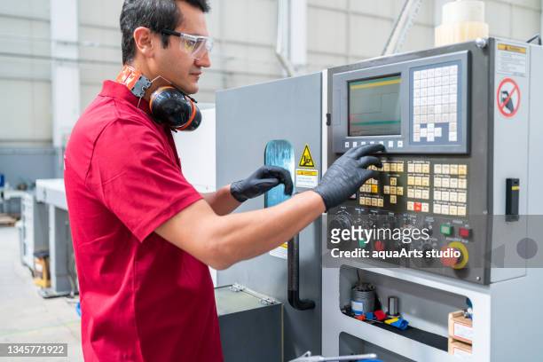 factory worker programming a cnc machine - cnc maschine stock pictures, royalty-free photos & images