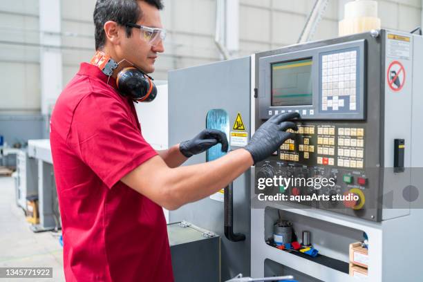 factory worker programming a cnc machine - operador de sistema telefónico imagens e fotografias de stock