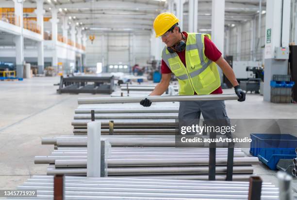 männlicher arbeiter, der in der stahlfabrik arbeitet - bog stock-fotos und bilder