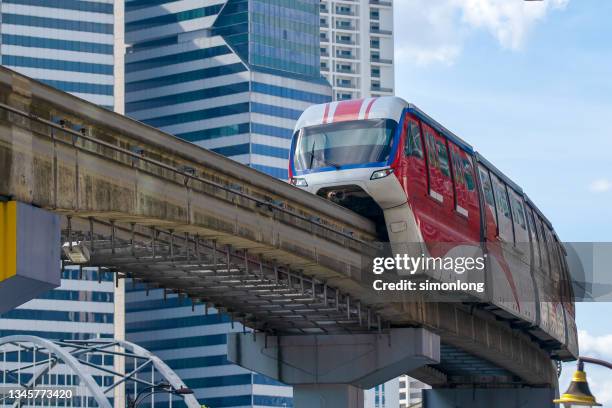 electric train on elevated track in the city - elektrische trein stockfoto's en -beelden