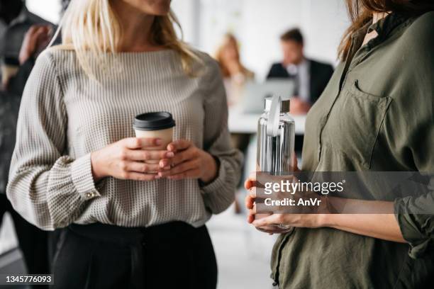 close-up of two business women on a coffee break - cup of water stockfoto's en -beelden