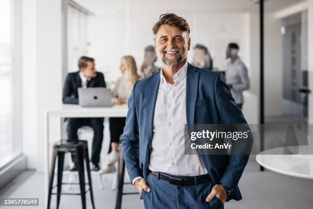 excited businessman smiling at the camera - 40 49 years stock pictures, royalty-free photos & images