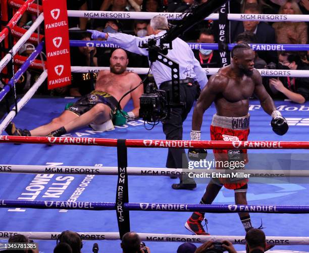 Deontay Wilder walks away after knocking Tyson Fury down as referee Russell Mora gives Fury a count in the fourth round of their WBC heavyweight...