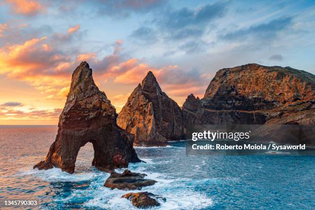 waves crashing on sea stacks rocks, madeira island - felsformation stock-fotos und bilder