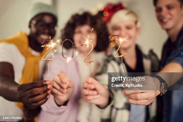 group of teenagers lighting sprinklers and celebrating new year - 18 23 months stock pictures, royalty-free photos & images
