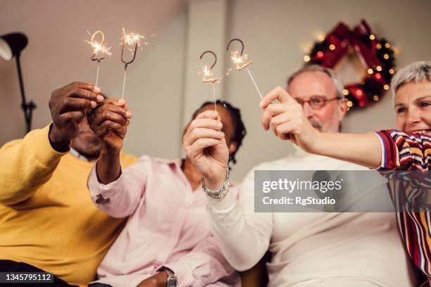 multiethnische gruppe älterer freunde, die gemeinsam silvester feiern - 40 year old black man stock-fotos und bilder