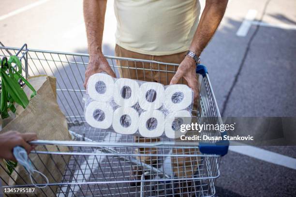 homme senior déballant le panier d’achat - buying toilet paper photos et images de collection