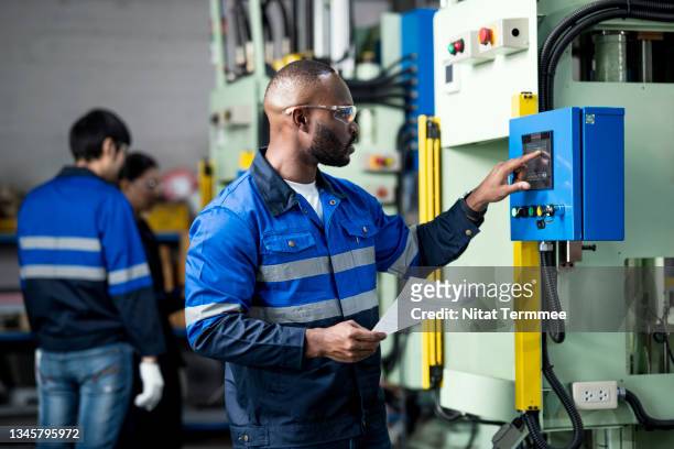 production planning & control is importance in the manufacturing industry. african chief production planning control engineer working at an automated machine while examining and monitoring the production progress. - system engineer stock pictures, royalty-free photos & images