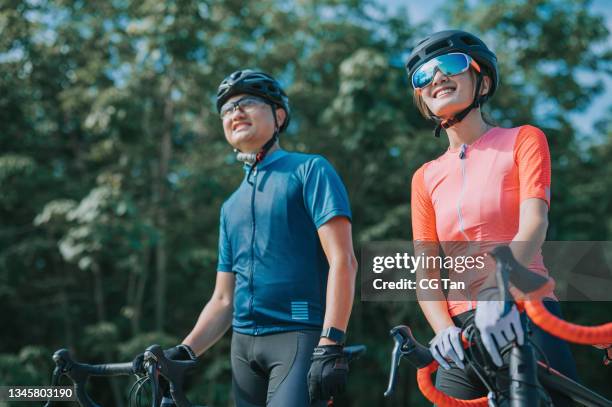portrait asian chinese couple cyclist looking away during weekend morning at rural scene - cycling team stock pictures, royalty-free photos & images
