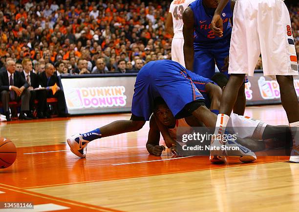 Dion Waiters of the Syracuse Orange looks for the ball from the floor as a Florida Gators player falls on top of him during the game at the Carrier...