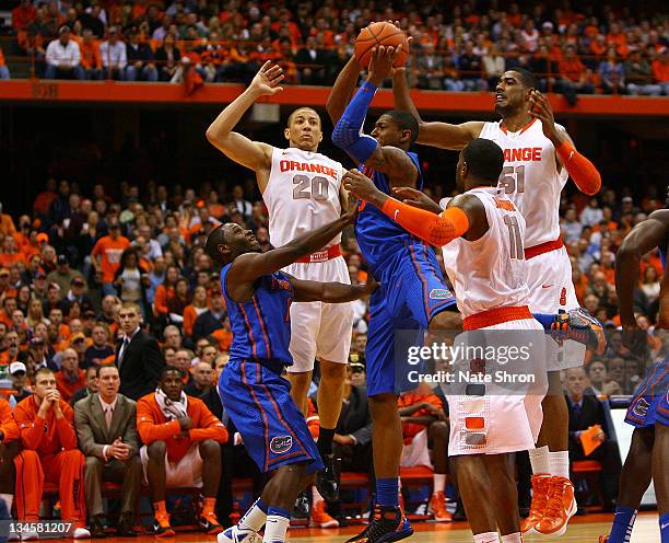 Bradley Beal of the Florida Gators shoots with the help of teammate Erving Walker against Brandon Triche, Scoop Jardine and Fab Melo of the Syracuse...