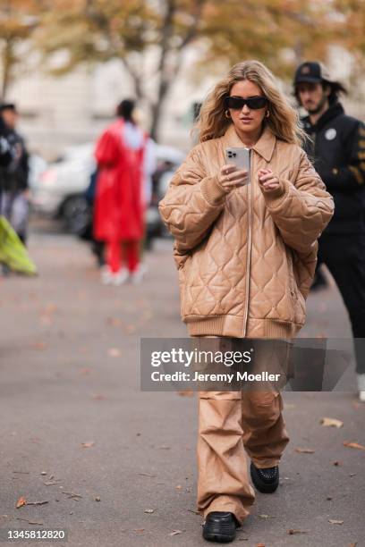 Emili Sindlev wearing a brown jacket, pants and black shoes outside Miu Miu Show on October 05, 2021 in Paris, France.