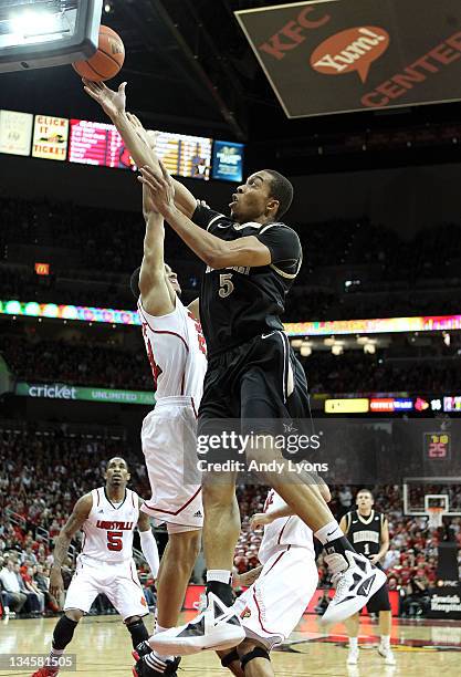 Lance Goulbourne of the Vanderbilt Commodores shoots the ball while defended by Jared Swopshire of the Louisville Cardinals reach for a rebound...