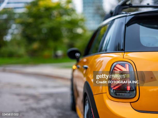 orange mini cooper in city park - union jack car stock pictures, royalty-free photos & images