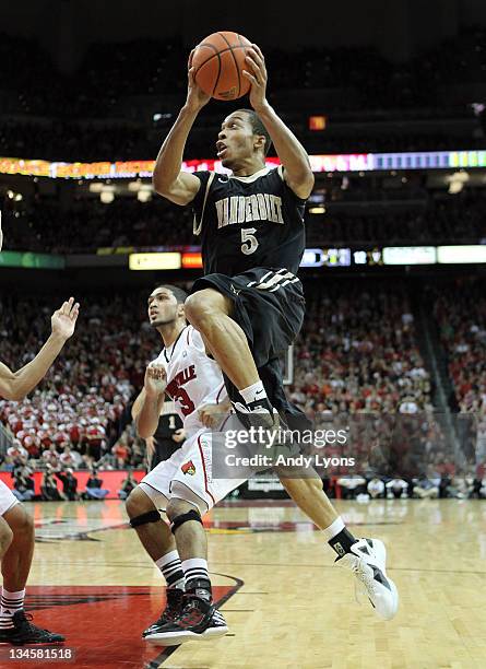 Lance Goulbourne of the Vanderbilt Commodores shoots the ball while defended by Jared Swopshire of the Louisville Cardinals reach for a rebound...