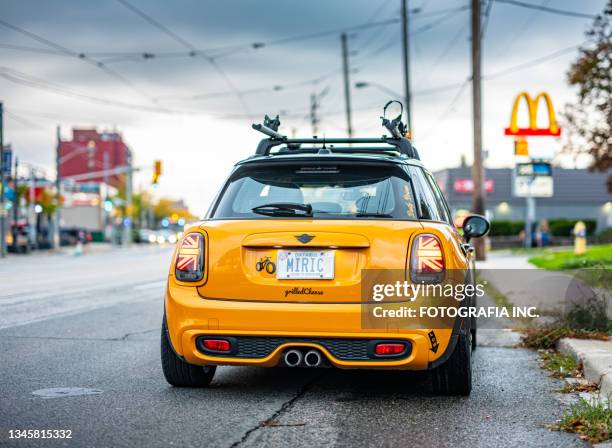 orange mini cooper on city boulevard - license plate stockfoto's en -beelden