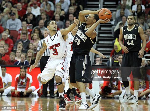 Peyton Siva of the Louisville Cardinals defends John Jenkins of the Vanderbilt Commodores during the game at KFC YUM! Center on December 2, 2011 in...