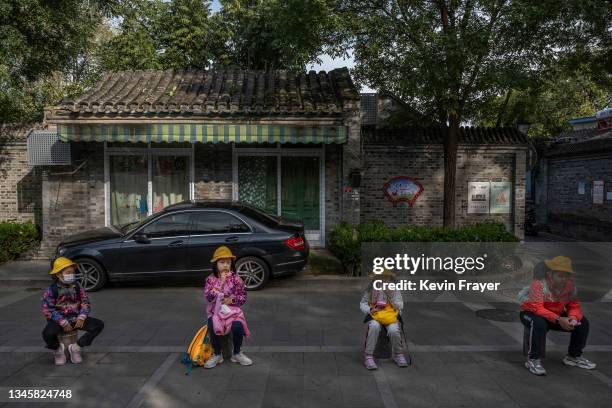 Children take a rest while touring in a traditional hutong neighbourhood on October 10, 2021 in Beijing, China. The historical centre of China's...