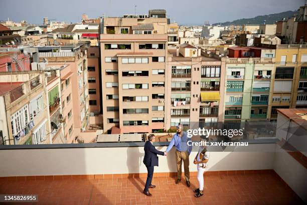 real estate agent and prospective buyers coming to an agreement - authentic real stockfoto's en -beelden