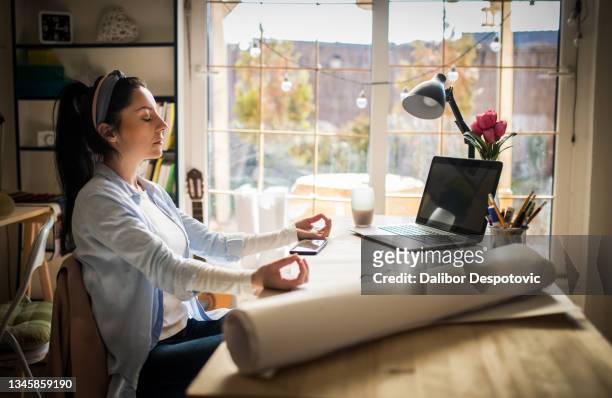 an ordinary woman meditates at her desk - bathroom exercise stock pictures, royalty-free photos & images