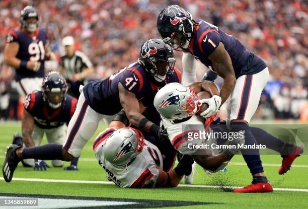 Damien Harris of the New England Patriots rushes for a touchdown as Lonnie Johnson of the Houston Texans and Zach Cunningham defend during the first...