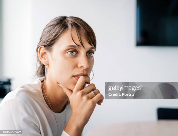 junge geschäftsfrau hört beim meeting zu - gray eyes stock-fotos und bilder