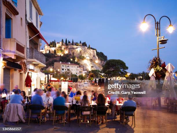 people dining outside in cassis fishing village - cassis stock-fotos und bilder