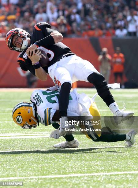 Joe Burrow of the Cincinnati Bengals is hit by Darnell Savage of the Green Bay Packers during the second quarter at Paul Brown Stadium on October 10,...