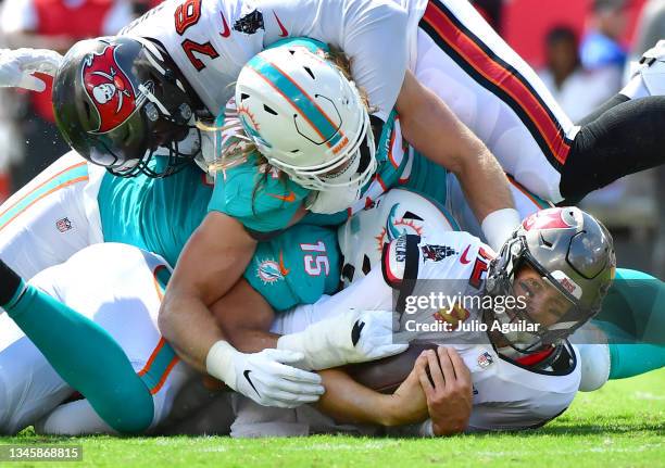 Tom Brady of the Tampa Bay Buccaneers is sacked by Jerome Baker of the Miami Dolphins during the second quarter at Raymond James Stadium on October...